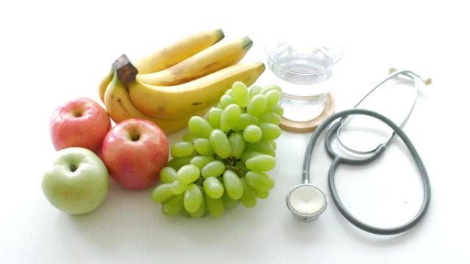 健康食品白色餐桌上的水果和听诊器背景健康概念
