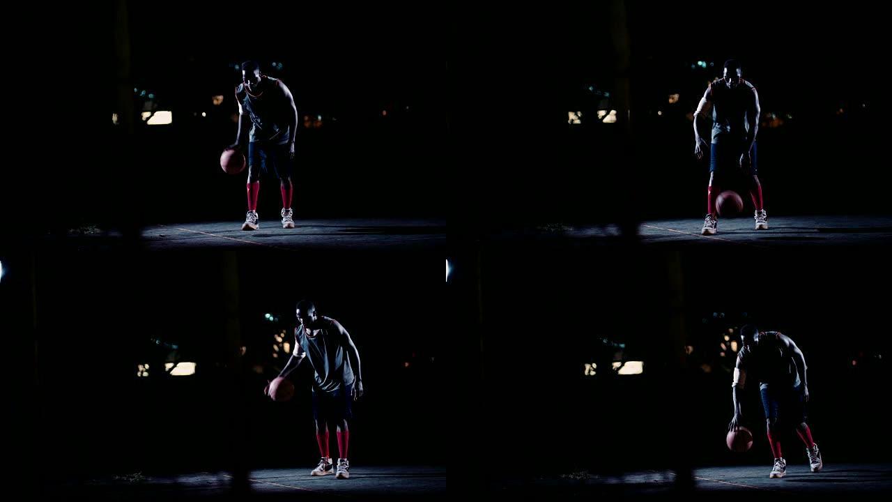 男子篮球运动员晚上在球场上弹跳球