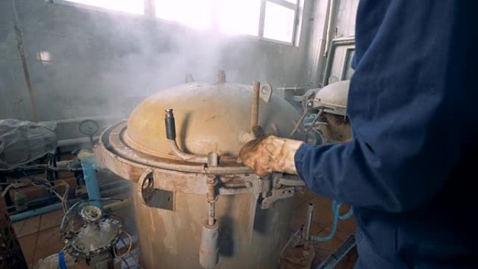 一名工厂工人用罐头封闭一个容器。