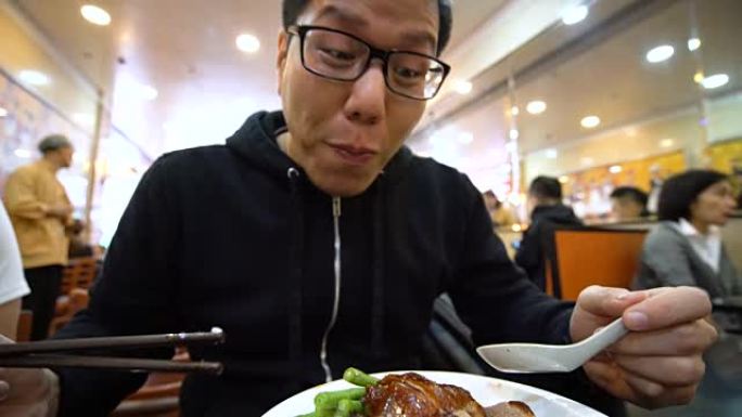 亚洲男子在当地餐馆吃烤鹅