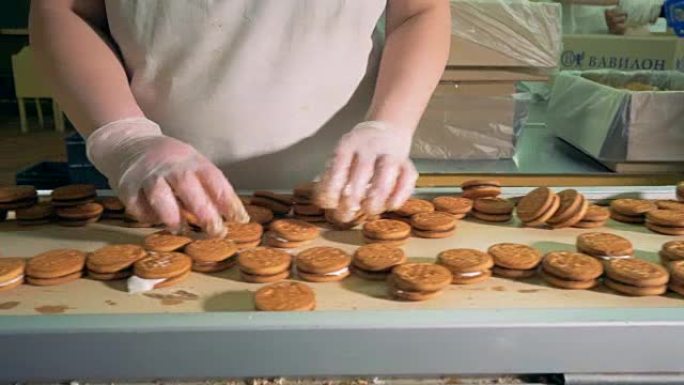 食品厂面包店生产的工人经营饼干输送机。4K。