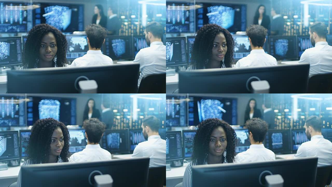女计算机工程师与她的多种族专家团队一起从事神经网络/人工智能项目。Office有多个屏幕显示3D可视