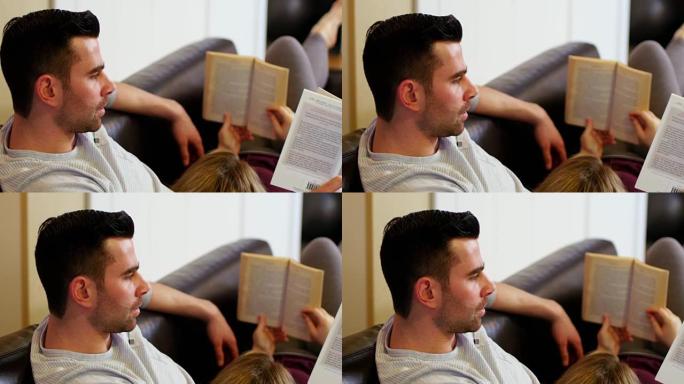 夫妇躺在沙发上看书