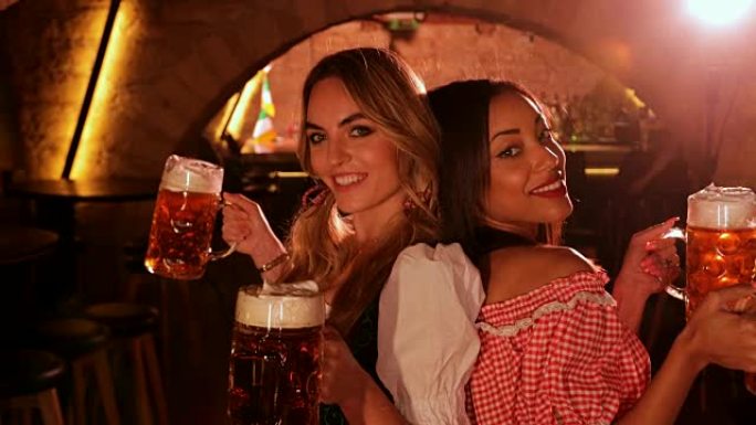 身着巴伐利亚服装的年轻多民族妇女用啤酒庆祝啤酒节