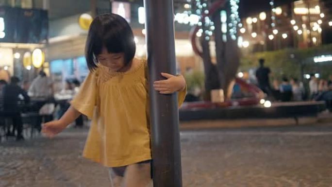 夜间人行道: 可爱的小女孩踩着