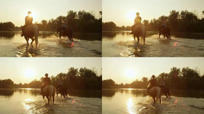 特写: 两名女骑手在神奇的日落时沿河骑马