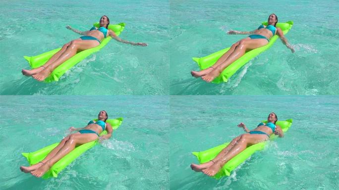 慢动作:快乐的年轻女子躺在充气的水上