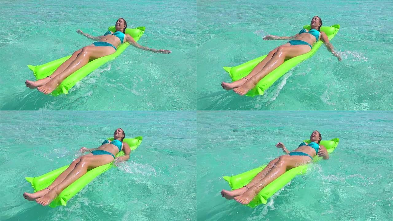 慢动作:快乐的年轻女子躺在充气的水上