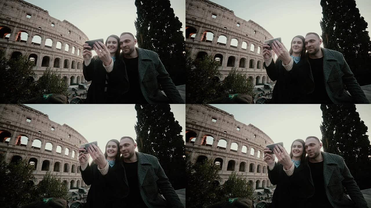 快乐的旅行夫妇一起在意大利罗马竞技场附近的智能手机上拍照留念