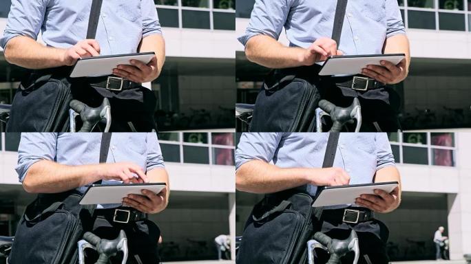 穿着衬衫的DS男子在办公楼前使用数字平板电脑