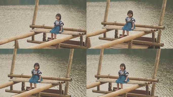 享受坐在山河上的小女孩