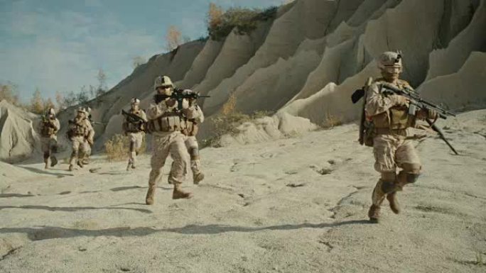 全副武装的士兵在沙漠中奔跑。显示运动。