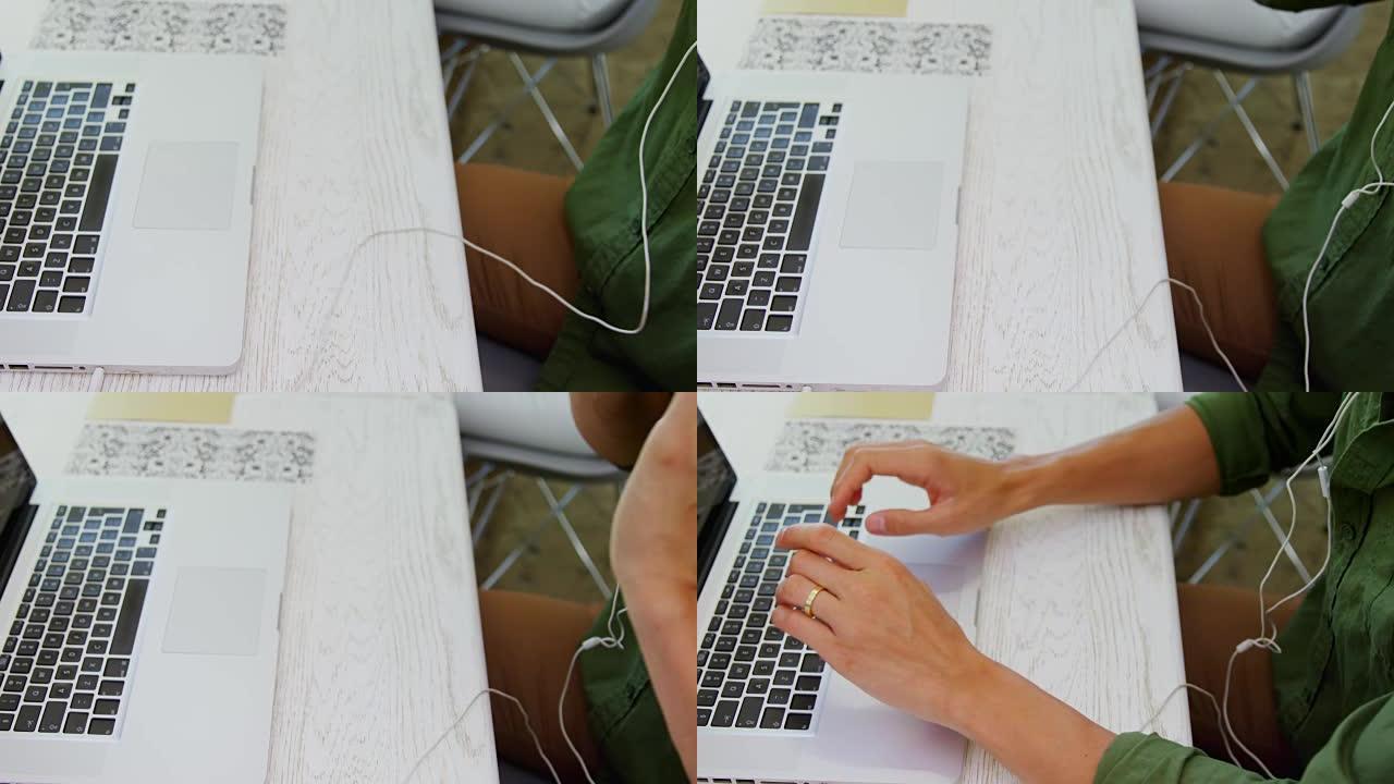 在4k办公桌上使用笔记本电脑时，执行人员收听歌曲的中间部分
