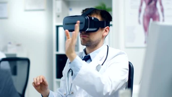 男医生戴着虚拟现实耳机进行实验医疗程序。他的助手密切监视办公桌上的活动。现代是轻盈和超现代的。
