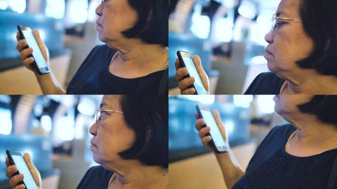 高级妇女在机场的智能手机上检查她的航班