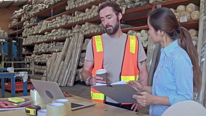 经理在仓库用笔记本电脑与工人交谈的实时视频