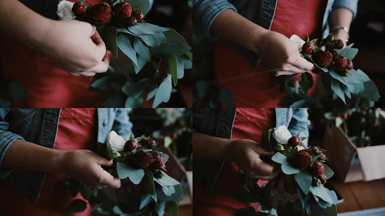 年轻女子花店制作美丽花朵的特写镜头。装饰师做花环