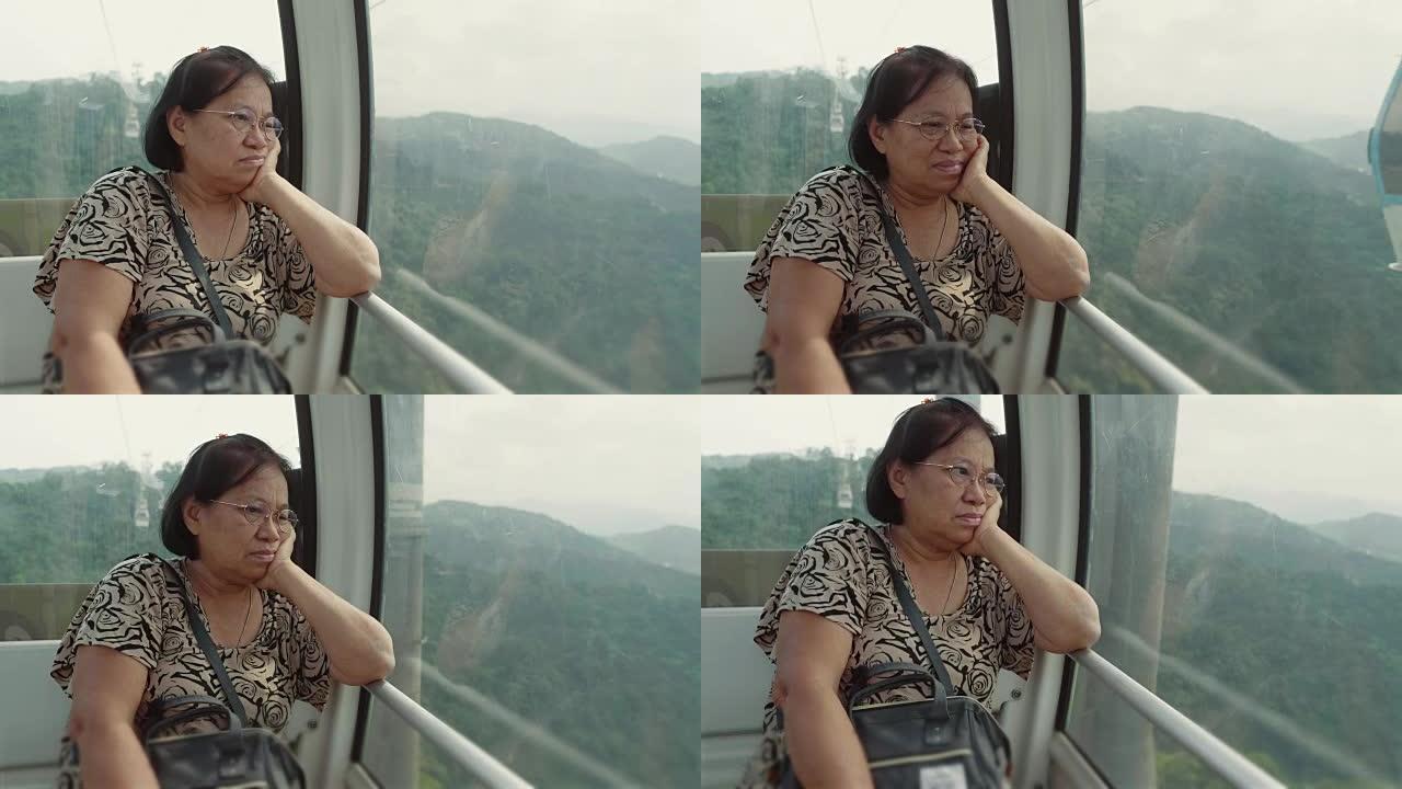 亚洲高级妇女从缆车看风景。