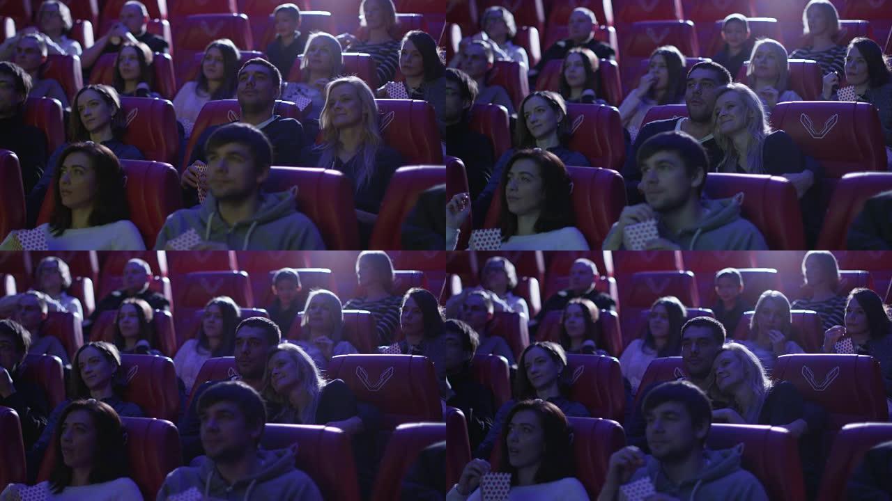 年轻的浪漫夫妇正在电影院观看电影放映。