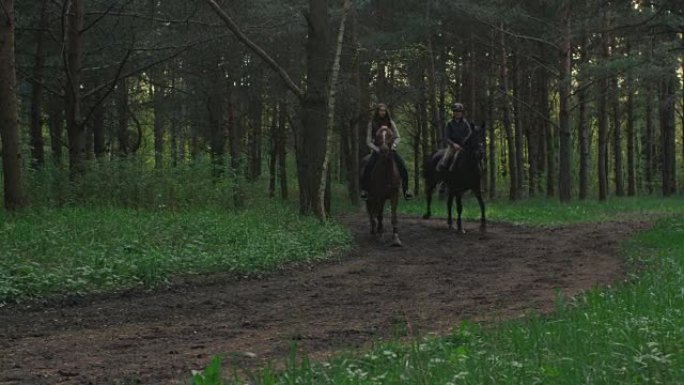 两个年轻女孩在森林里骑马