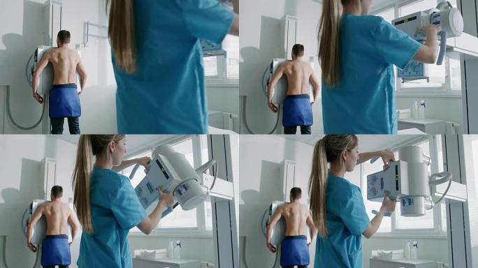 在医院里，一名男子面对墙壁站着，而医疗技术人员则调整x光机进行扫描。扫描骨折，四肢骨折，胸部，癌症或