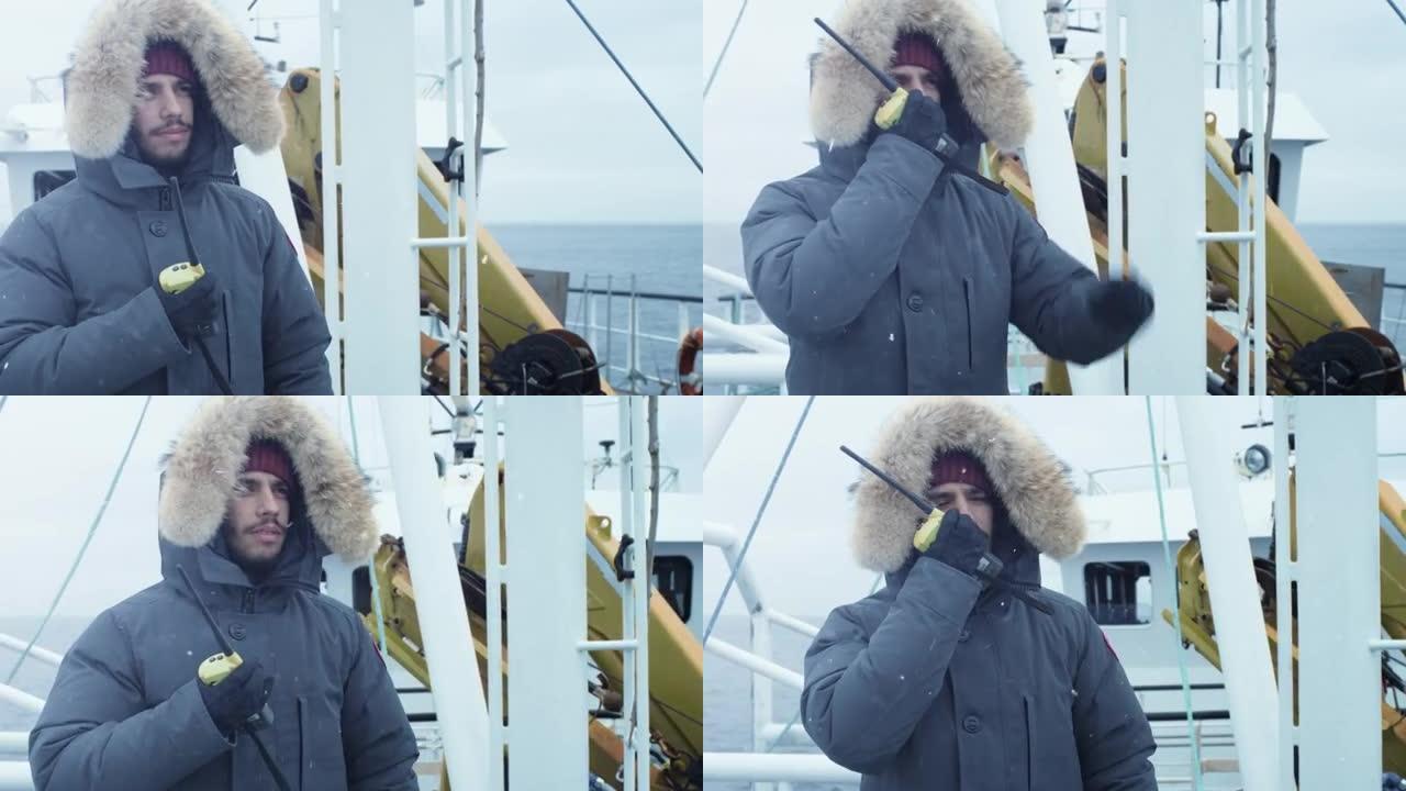穿着保暖夹克的冒险家站在船上，用收音机交流。大雪纷飞