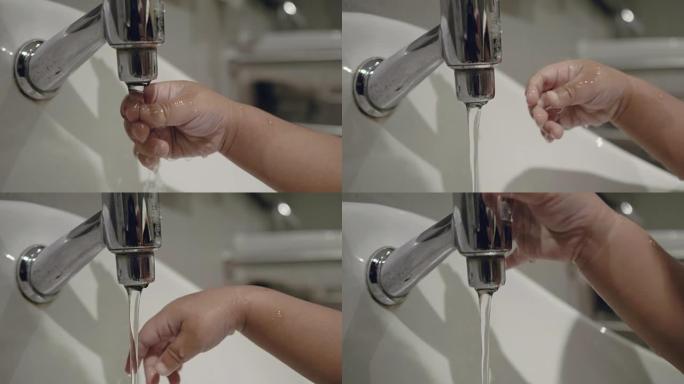 亚洲小男孩在浴室洗手。