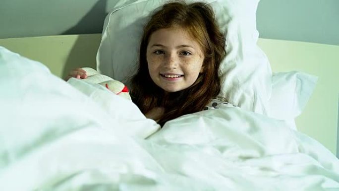 一个可爱的女孩躺在床上的肖像。
