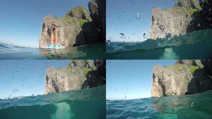 一半: 运动的年轻人潜入泰国完美的翡翠海水