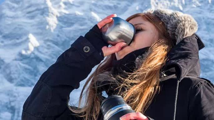 年轻女子用热水瓶喝水