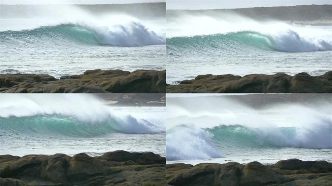 慢动作: 美丽的波浪向岩石海岸滚动