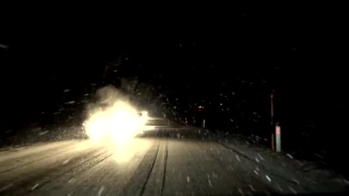 FPV，慢动作: 夜间在大雪中，汽车在主要道路上缓慢行驶