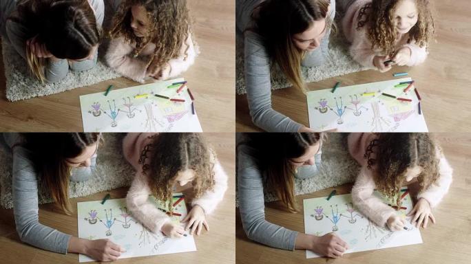 Mother and daughter coloring drawings on the floor