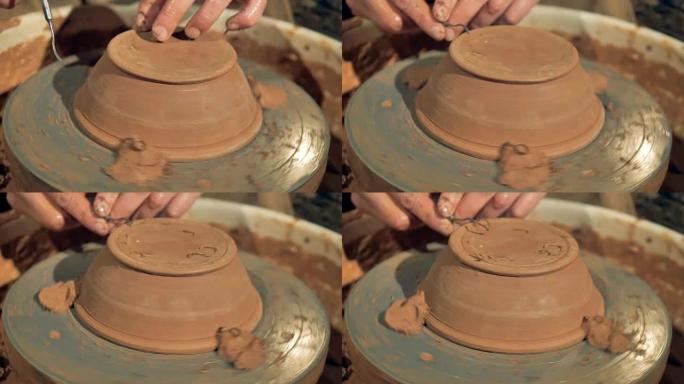 一个陶工雕刻着一个新碗的脚。