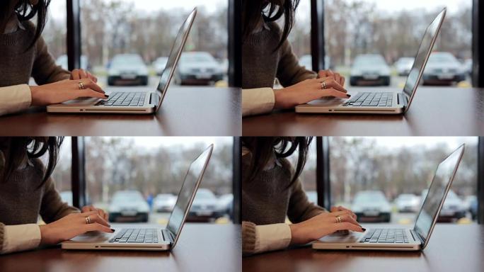 咖啡馆里的女性手在笔记本电脑上工作。向左滑动