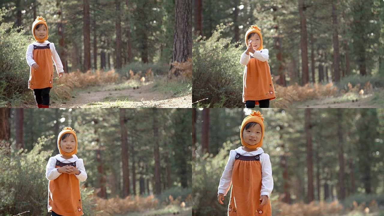 亚洲小女孩独自走在森林里，正面