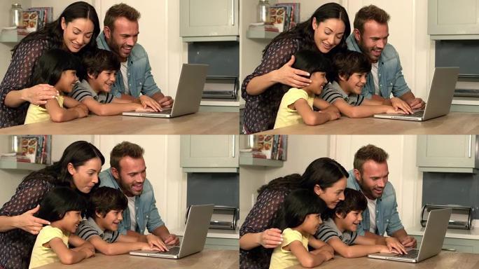 幸福的家庭在厨房里一起使用笔记本电脑