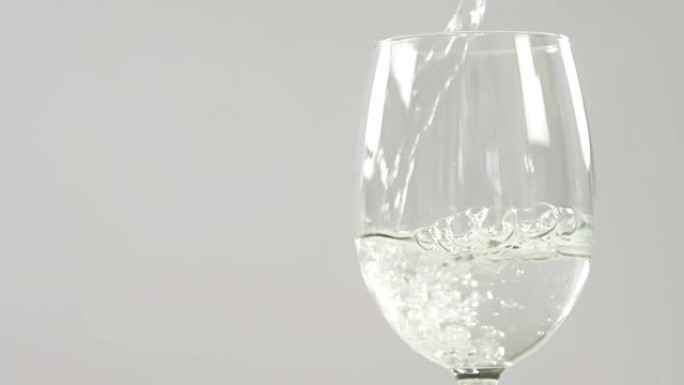 白葡萄酒落在白色背景下的玻璃杯中