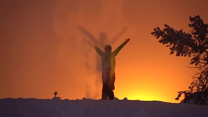 慢动作: 在天空中撒雪，在金色的日落时自豪地举起手臂