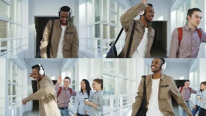 多莉拍摄的年轻英俊的非裔美国学生在大学的白色走廊上跳舞，注意到他的朋友打招呼，然后继续戴着大耳机听音
