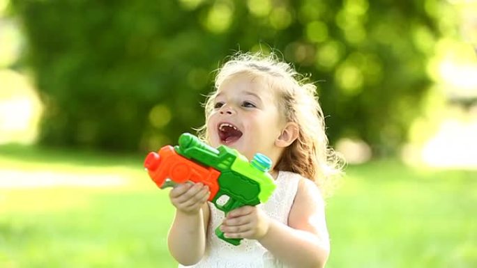 小女孩在使用水枪时微笑