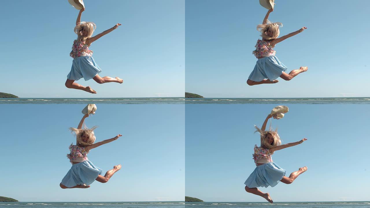 迷人的金发女郎拿着草帽在海滩上跳跃