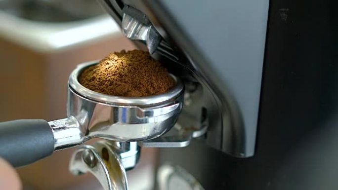 4k咖啡师在门式过滤器中研磨和捣固咖啡。