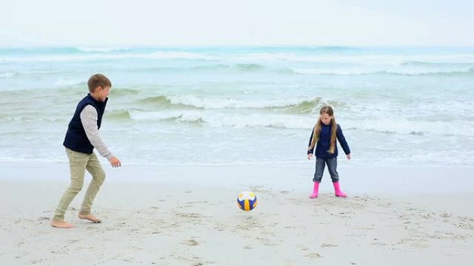 兄弟姐妹在沙滩上踢足球