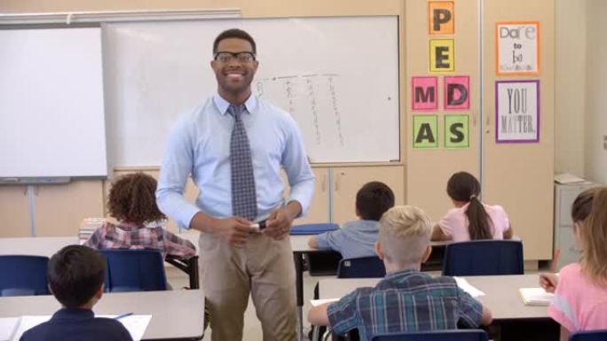 快乐的黑人男老师走过教室走向镜头
