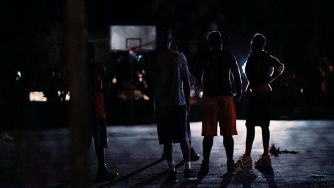 篮球运动员在夜间在法庭上比赛