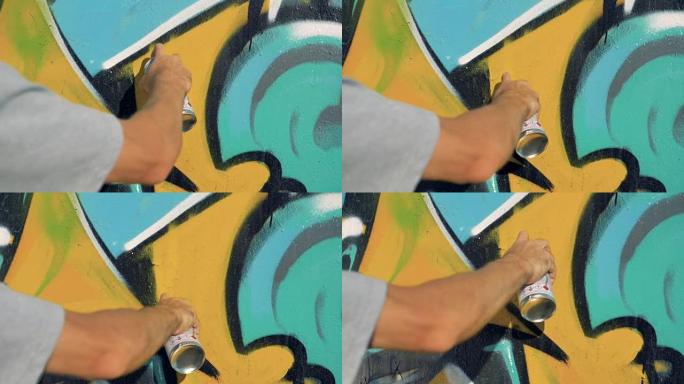 一只手在墙上重新粉刷涂鸦。