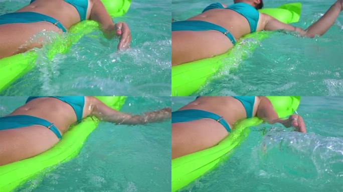 慢镜头特写:女人游泳在异国情调的绿松石泻湖海洋