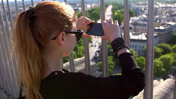 女人通过从凯旋门顶部拍摄巴黎的照片来创造回忆