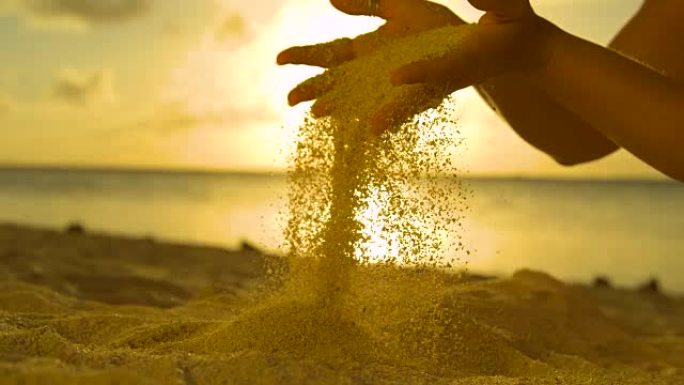 反向慢动作: 沙子从女孩的手指上掉下来，回到海滩上